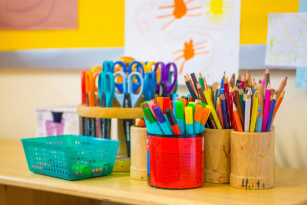Colouring pens, scissors, pencils on the table in nursery