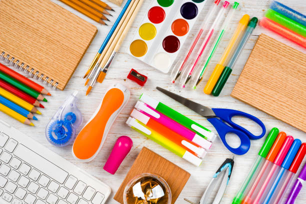 Top view of school and office supplies on wooden table